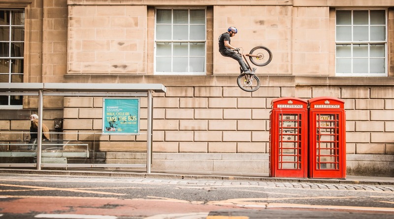 photo of person mid air on bike over a street