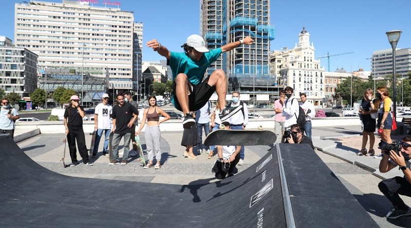 photo of people watching a person performing a skating stunt