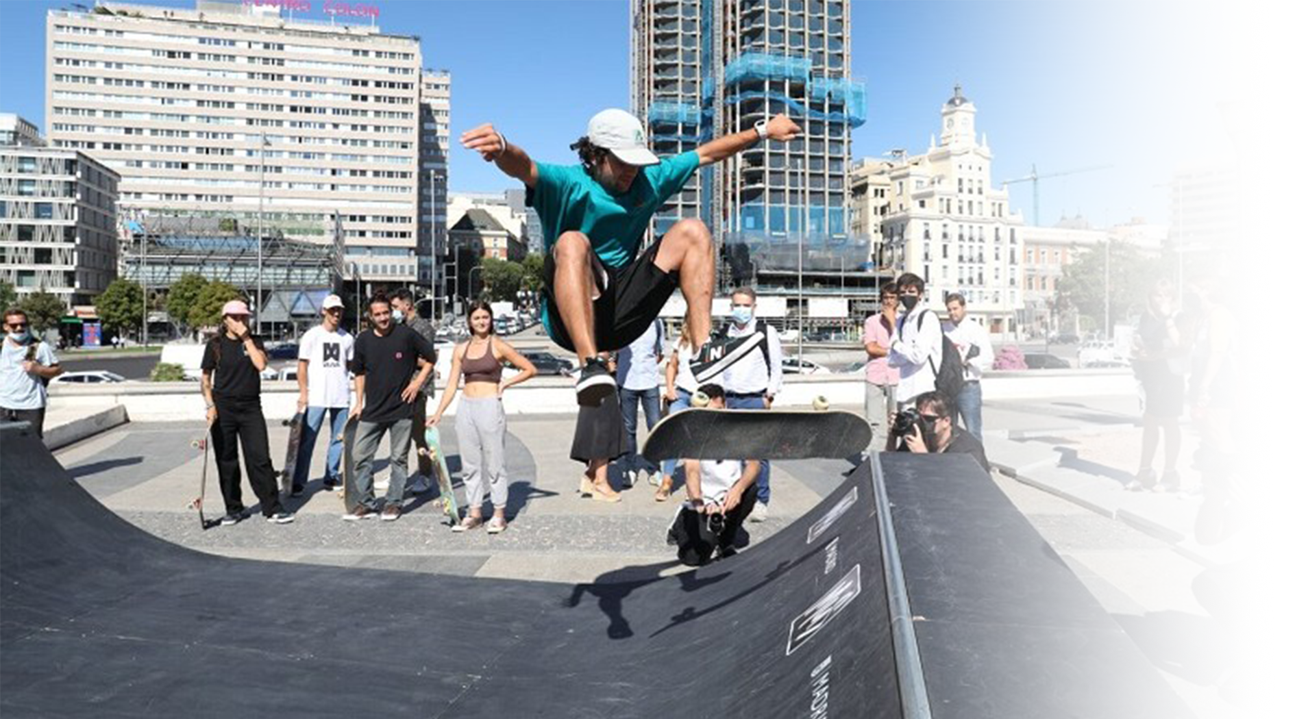 photo of skater performing a stunt at a skate park in front of a crowd of people